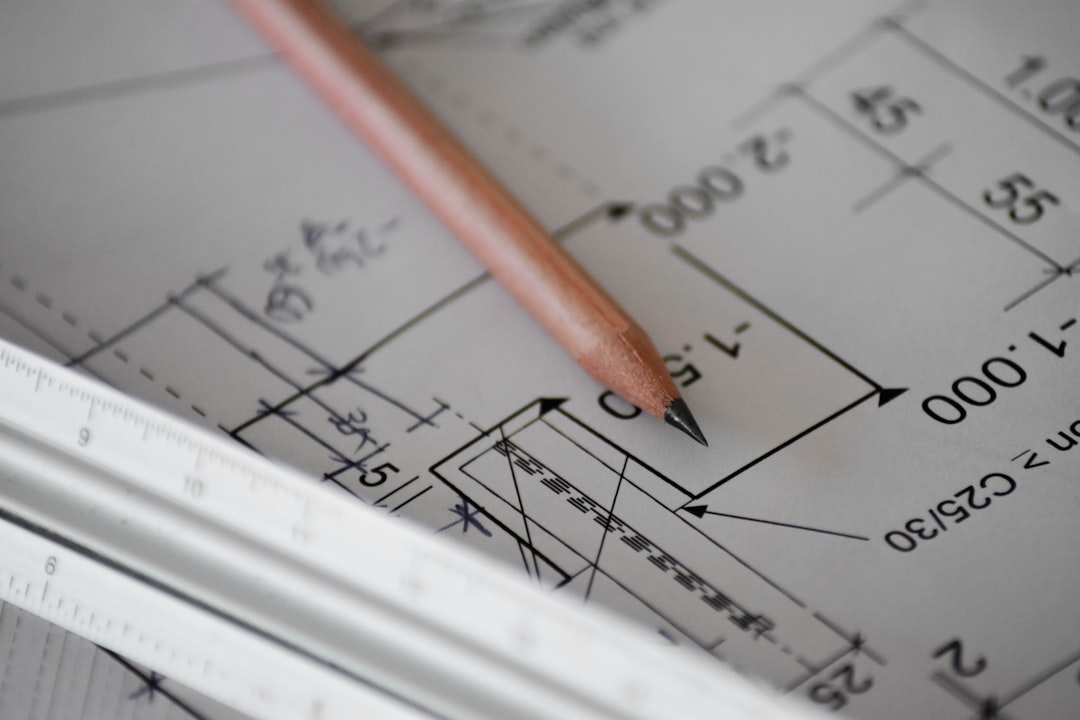 Photo of a builder reviewing a detailed line-item estimate spreadsheet at a jobsite with framing in the background