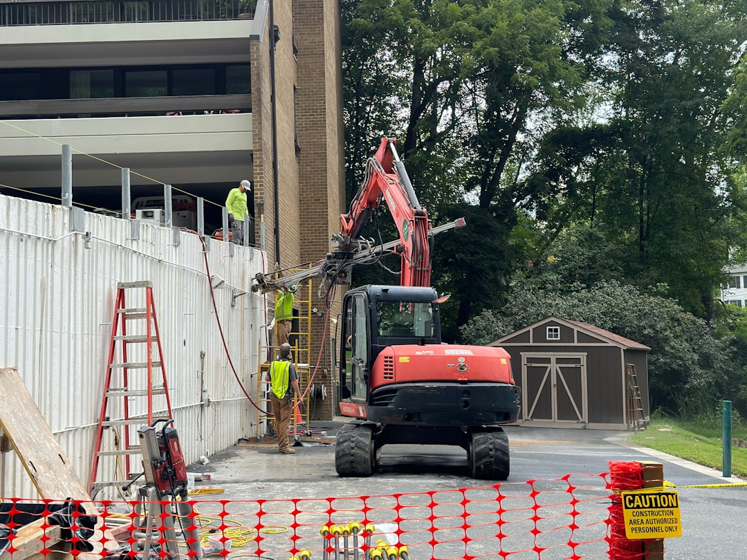 Construction crew excavating and forming a foundation with drainage and waterproofing visible