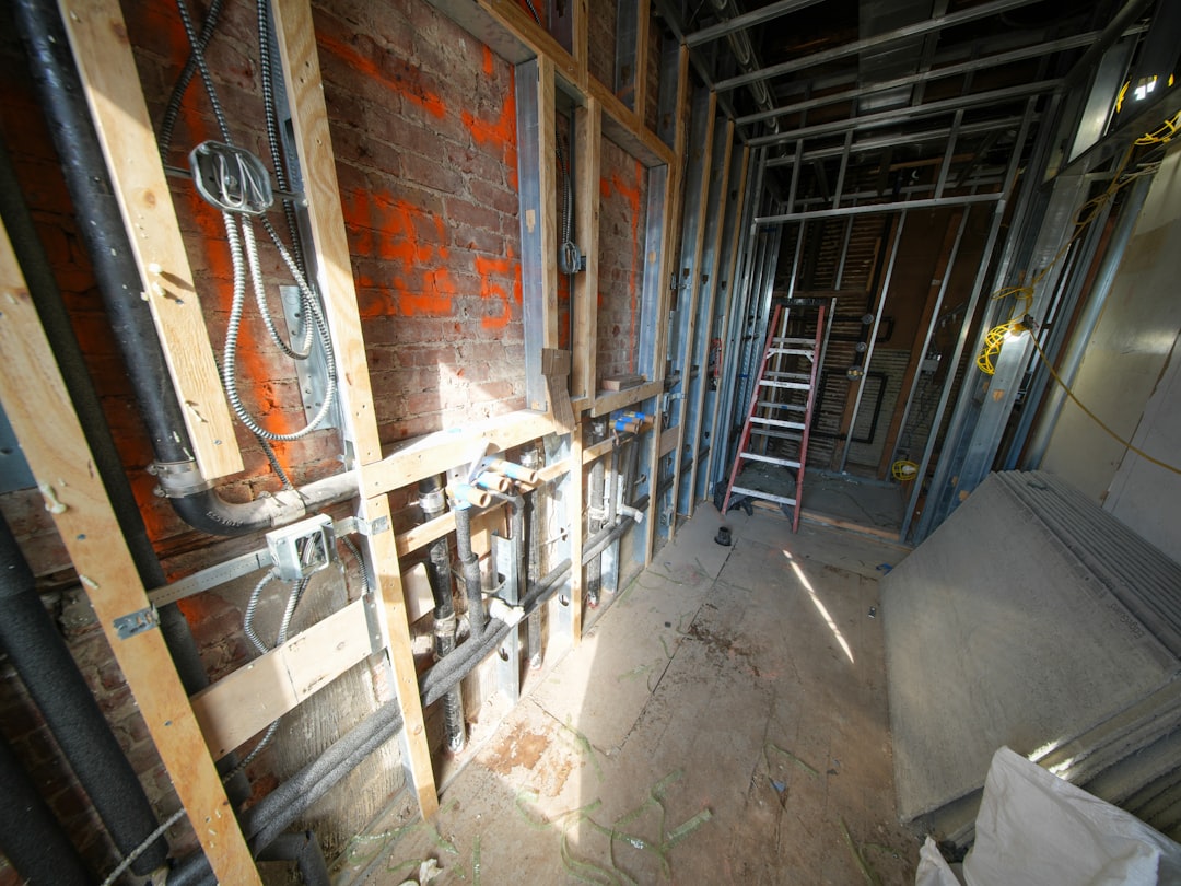Electrician rough-in wiring in new construction studs with boxes and cable runs